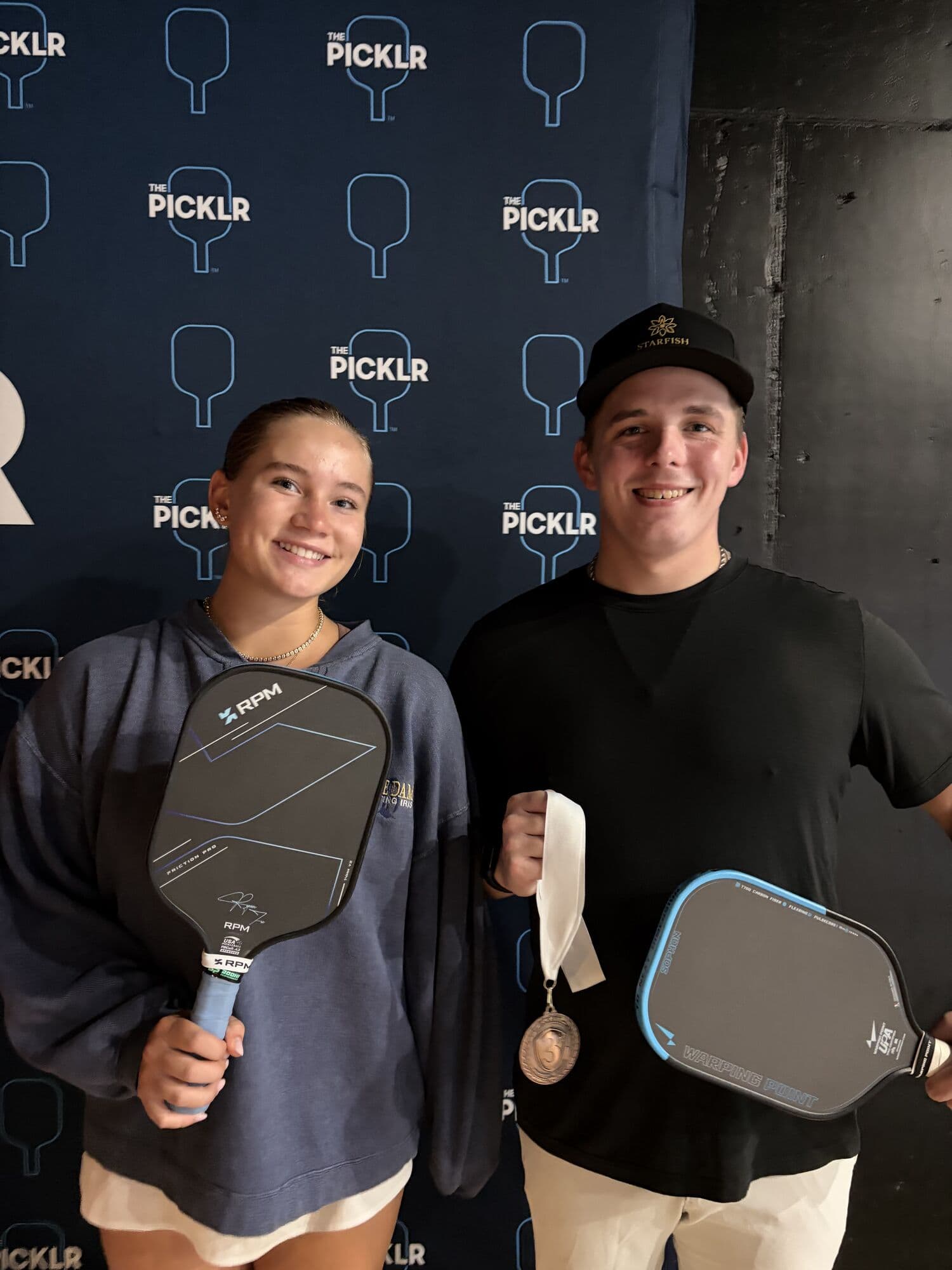Mixed doubles medalists holding their paddles and medals